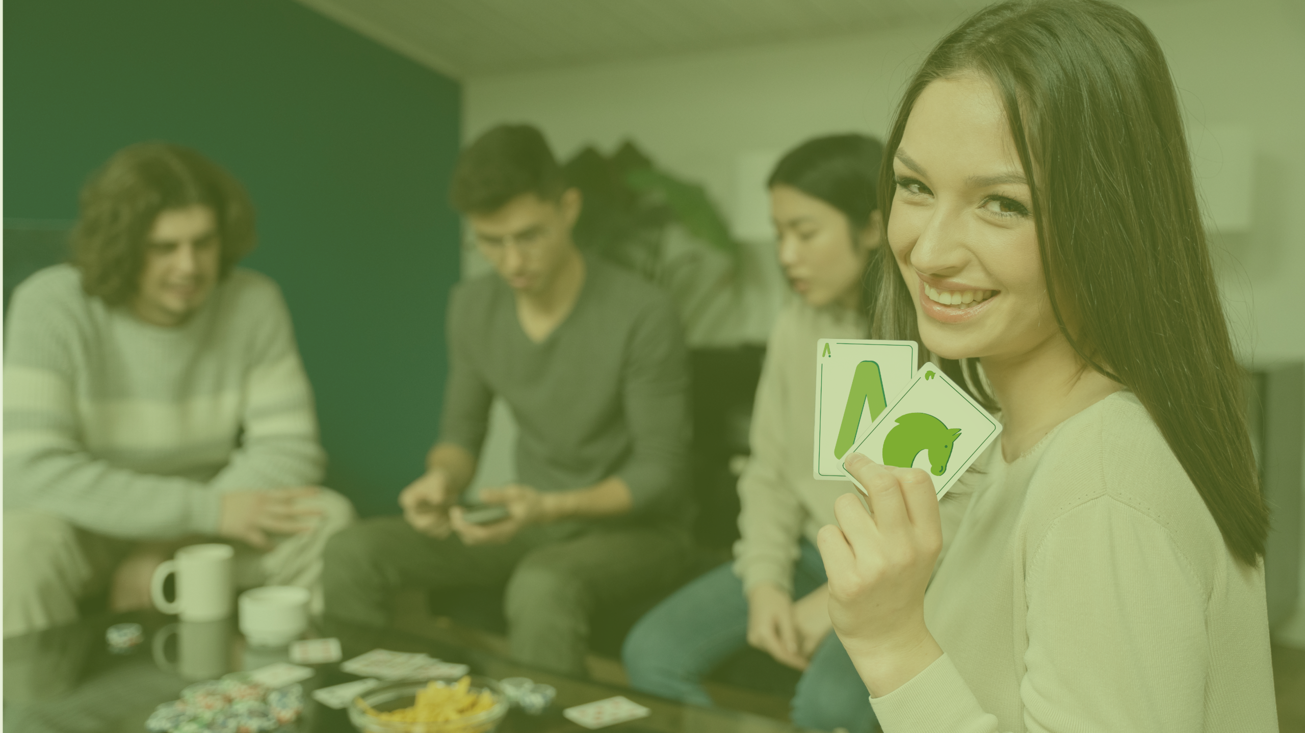 Un grupo de chicos jugando a las cartas, con tres personas en el fondo ligeramente difuminadas. Una chica en primer plano sostiene dos cartas de nuestras tarifas AS y Caballo.